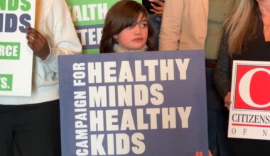 Emmi Murdi, a 10-year-old advocate holding a sign saying "Healthy Minds Healthy Kids"