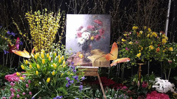 Colorful plants surround a floral painting at the Capital Region Flower and Garden Show