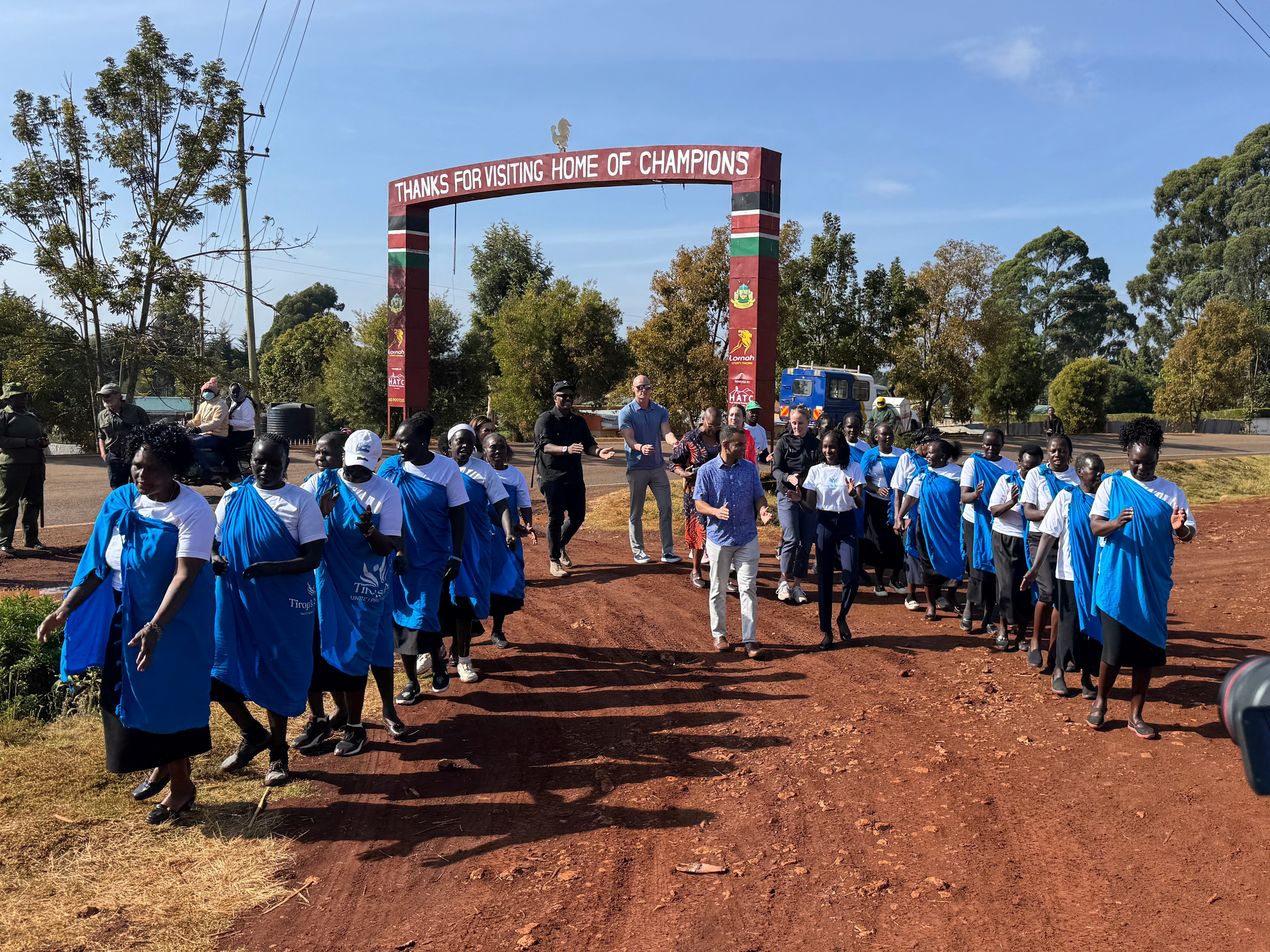 Rob Simmelkjaer and the NYRR team being greeted in Iten, Kenya by Viola and members of the Tirop's Angels community.