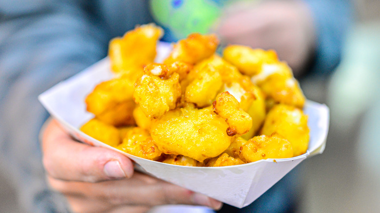 person holding basket of cheese curds