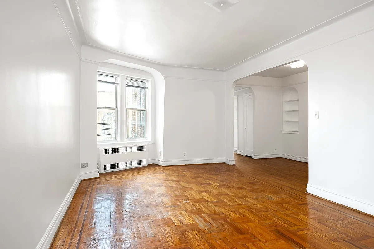 living room with arched opening for windows and an arched doorway to foyer