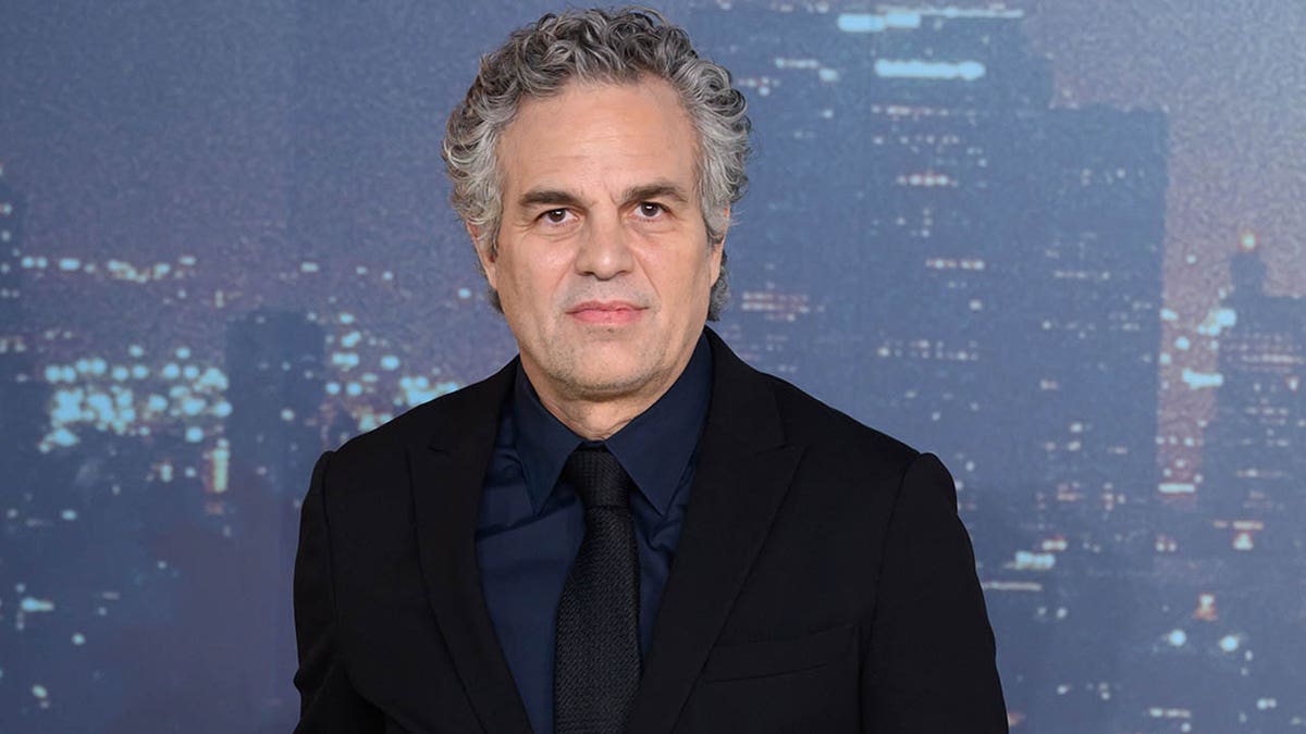 Mark Ruffalo standing against a city background 