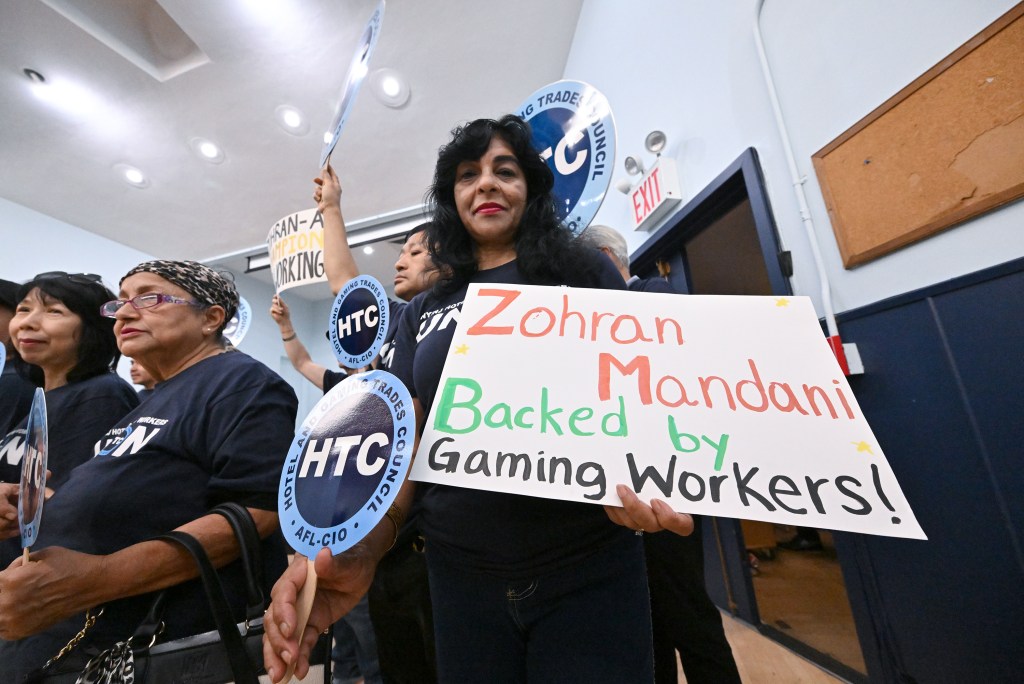 A group of labor union members holding signs in support of Zohran Mamdani.