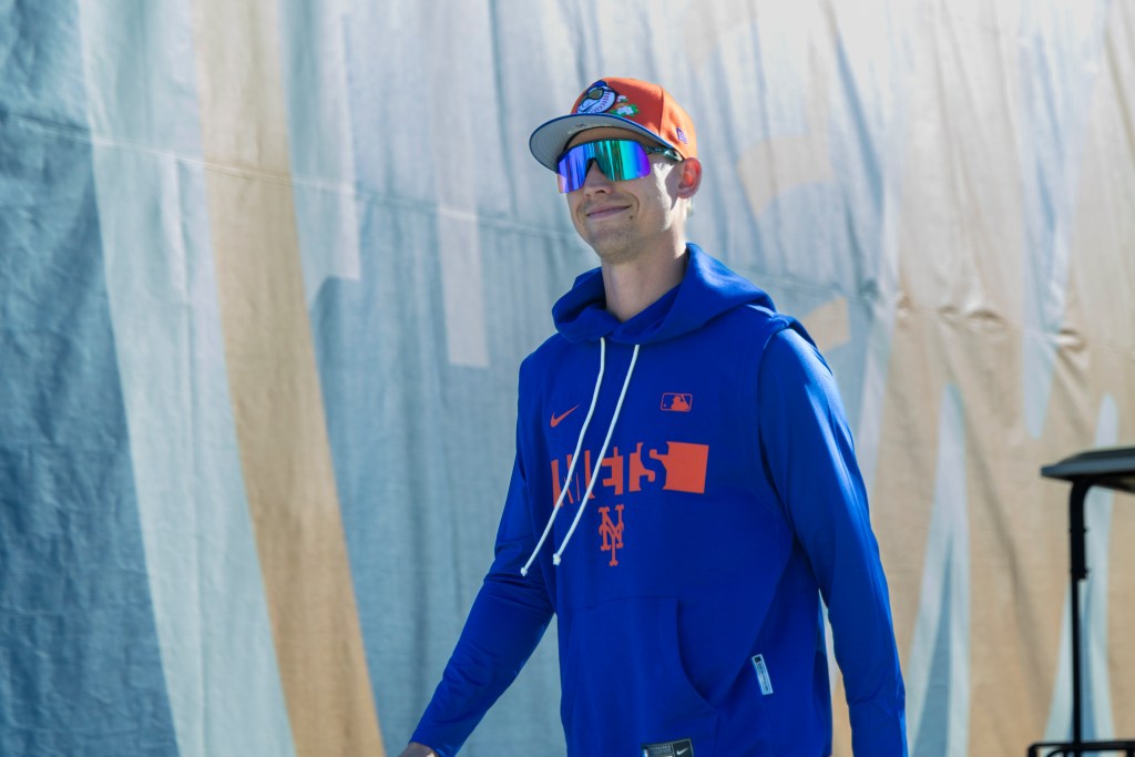 New York Mets pitcher Luke Weaver in a blue hoodie and orange cap.