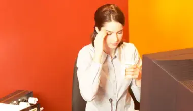 person sitting at desk in front of desktop computer, rubbing temples; NYC DCWP Publishes ESSTA Amendments FAQs and Form Notices