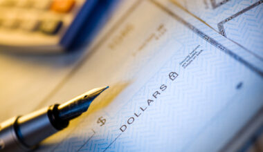 Partial image of a fountain pen sitting on top of a blank check