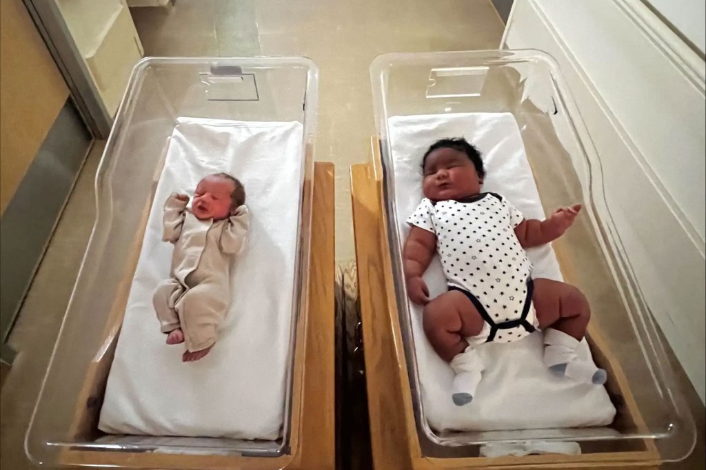 Two newborns of vastly different sizes in hospital bassinets.