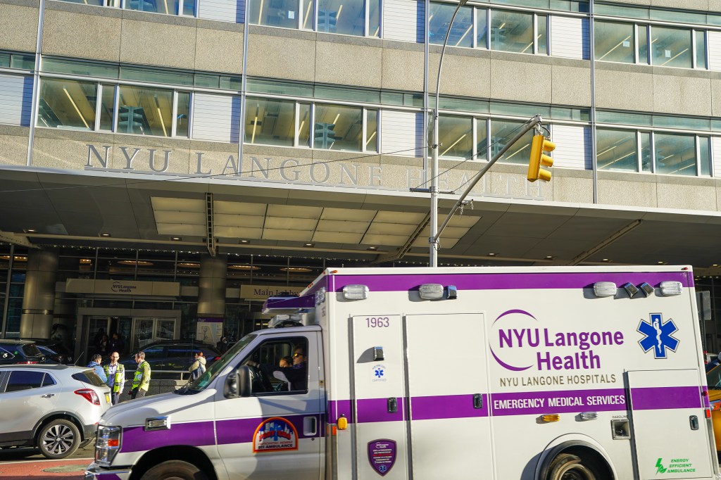 NYU Langone Health building with an ambulance driving by.