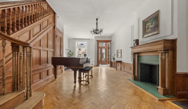 parlor with mantel, staircase, wood floor