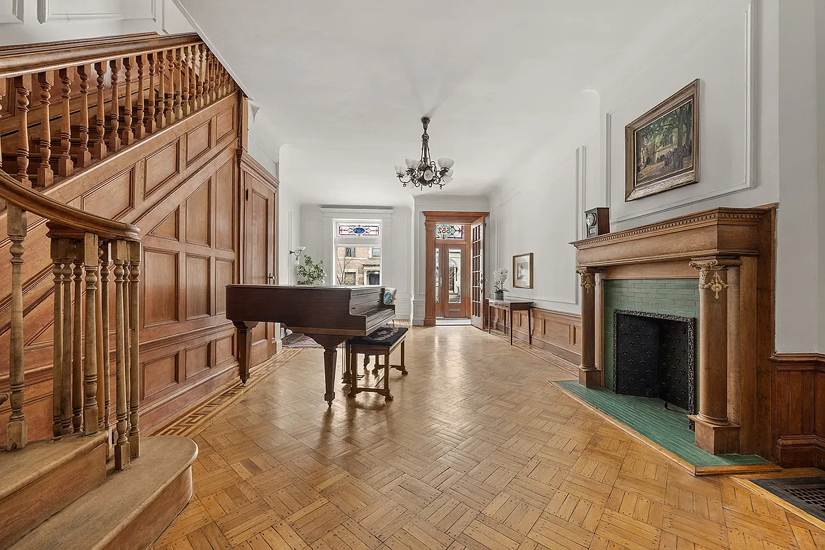 parlor with mantel, staircase, wood floor