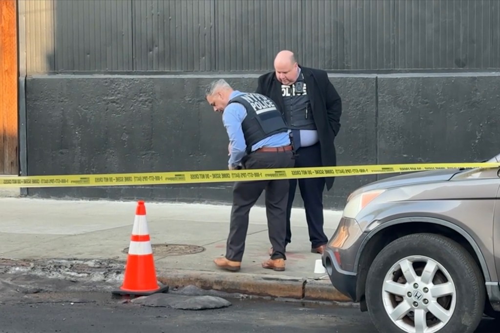 Police officers investigating a crime scene where a woman was shot in the leg.