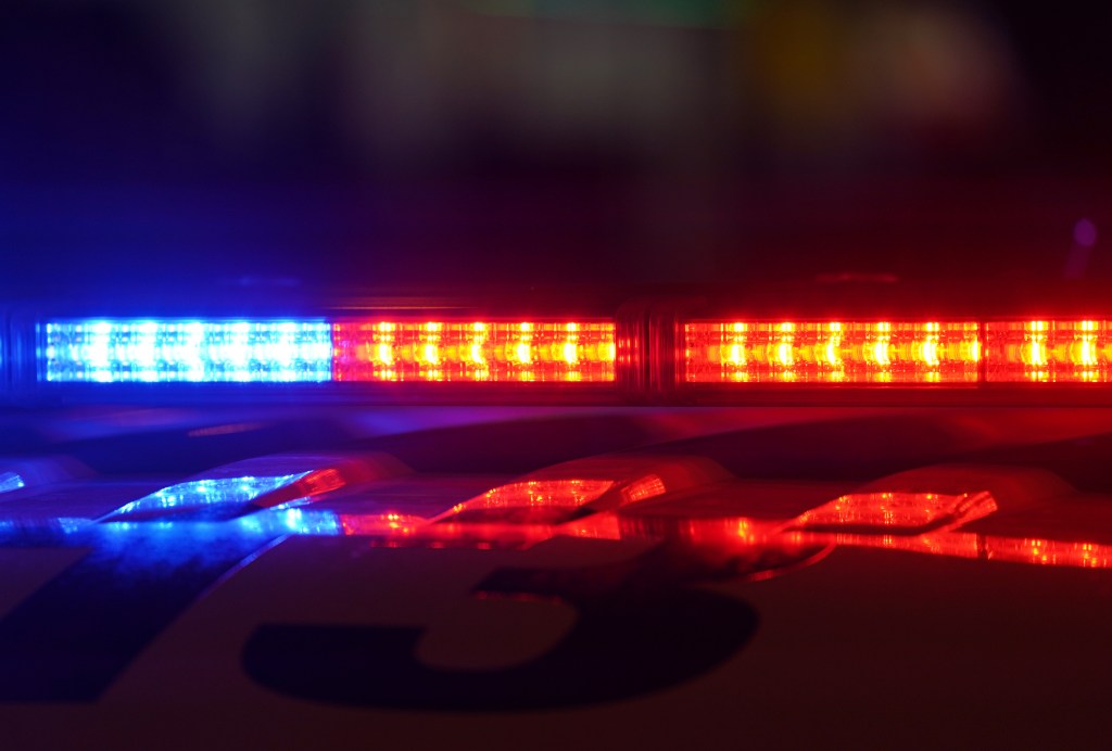 Police car emergency lights, with blue and red lights visible.