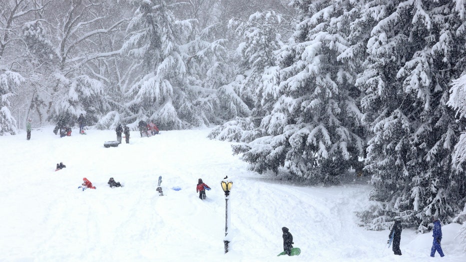 Children sled on Cedar Hill in Central Park in New York on February 23, 2026 during a snow storm. More than 40 million people were under blizzard warnings in the northeast United States on Monday, as a winter storm dumped shin-deep snow and officials in New York enforced a citywide travel ban. The so-called "Nor'easter" pummeled the region overnight, disrupting flights and leaving hundreds of thousands of homes and businesses without power. (Photo by TIMOTHY A. CLARY / AFP via Getty Images)
