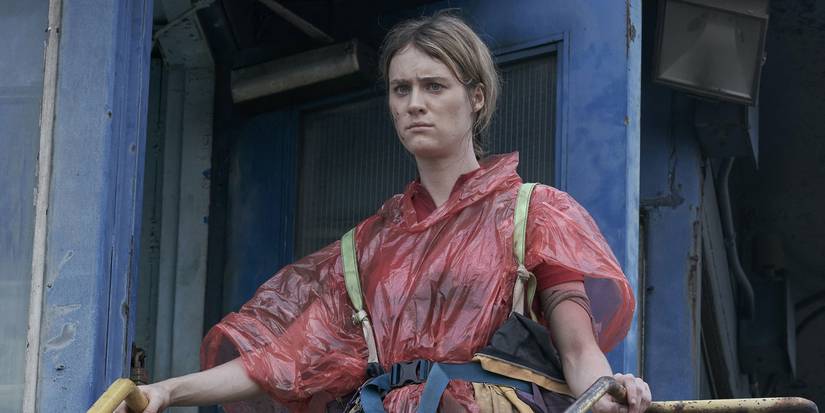 Mackenzie Davis as Kirsten wearing found materials as clothes with a serious expression in Station Eleven