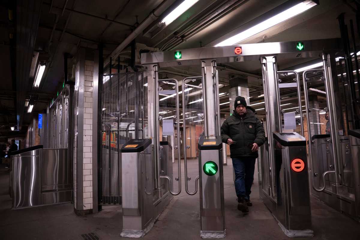 people passing through subway turnstiles to pay fare