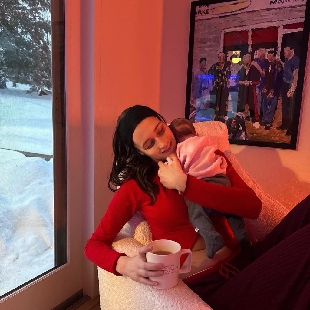 New mom Elsie Hewitt enjoys a coffee while holding her newborn. 