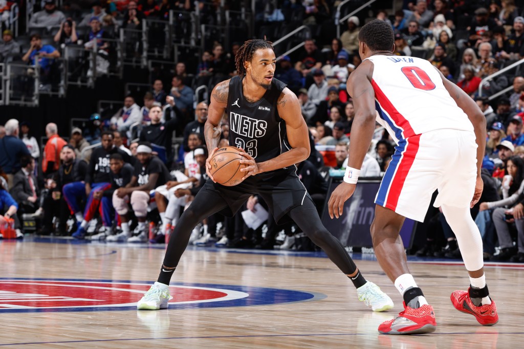 Nic Claxton of the Brooklyn Nets handles the ball against a Detroit Pistons player.