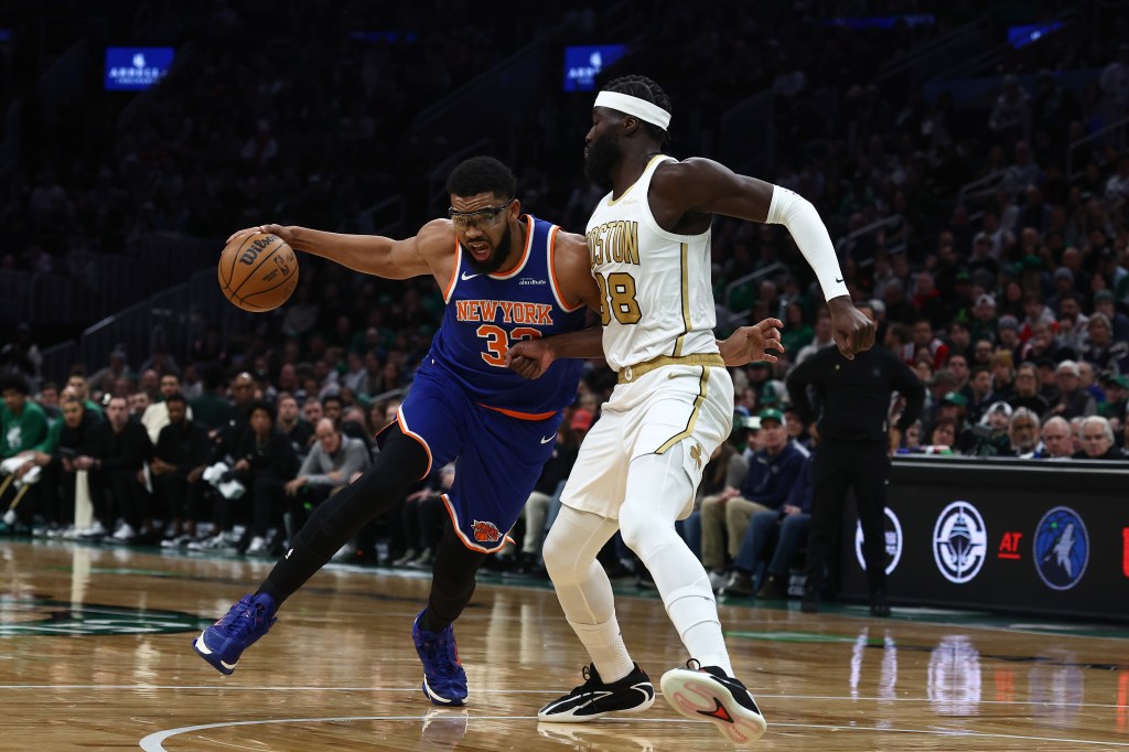 Karl-Anthony Towns of the New York Knicks drives against Neemias Queta of the Boston Celtics.