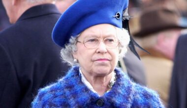 Queen Elizabeth Il Looking Serious Before The Race On Gold Cup Day At The Cheltenham National Hunt Festival While Wearing a Blue and Purple checkered coat and a royal blue hat
