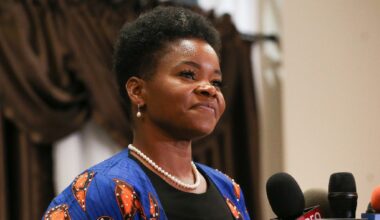 india walton stands at podium, microphones in front of her