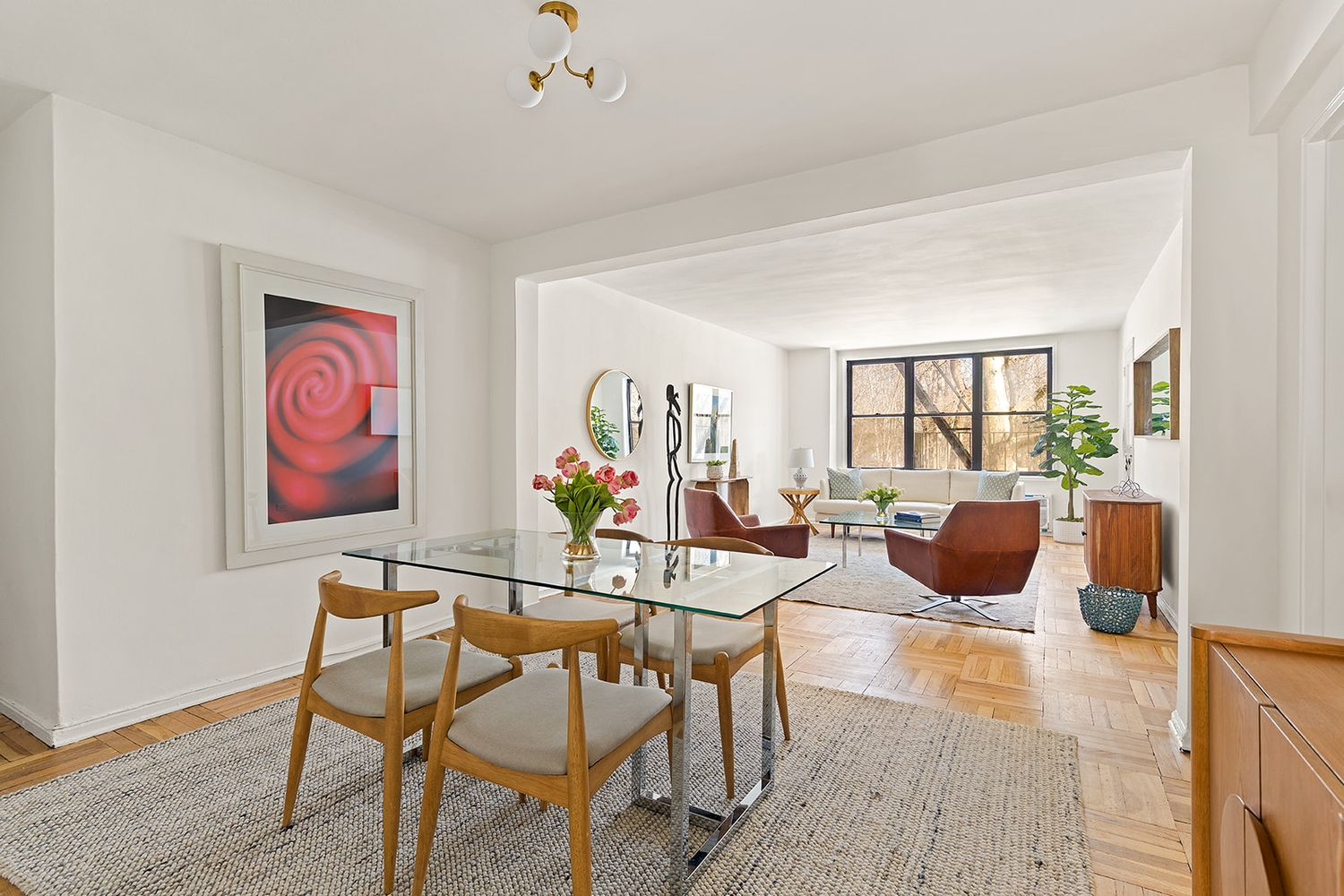 foyer open to living room, both with white walls and wood floors
