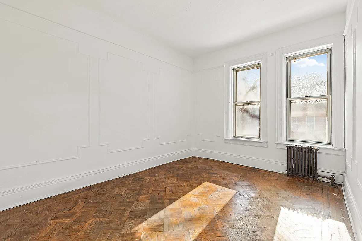 bedroom with wood floor, picture rail, white walls