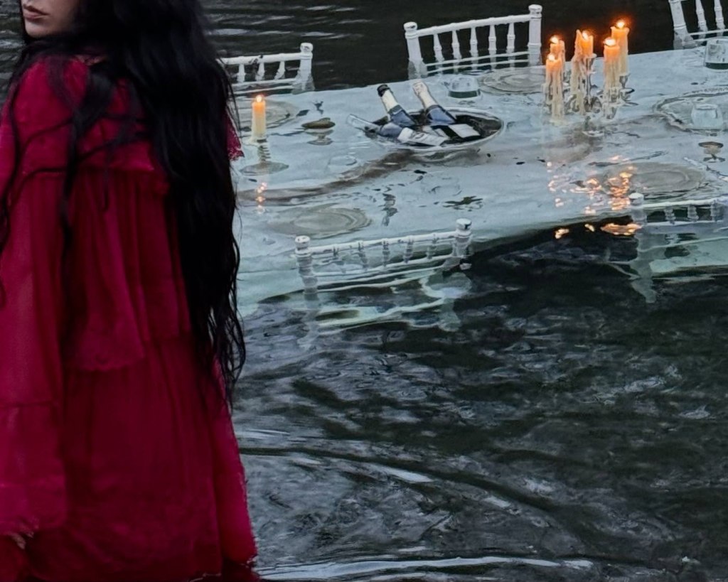 Charli XCX posts a surreal snap of a sunken dinner table for "Wuthering Heights" release week. 