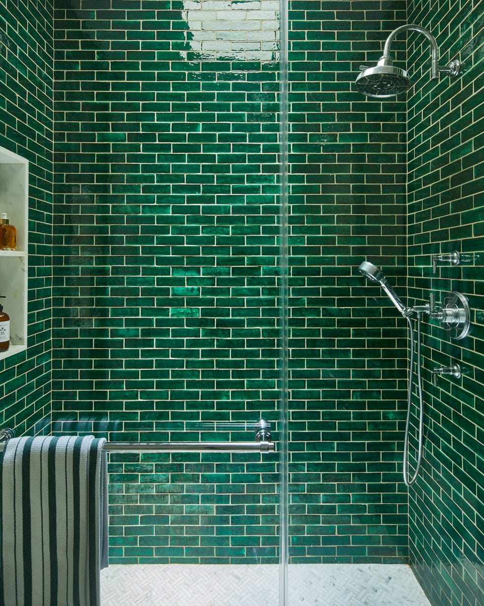 shower area featuring green subway tile walls and metallic fixtures