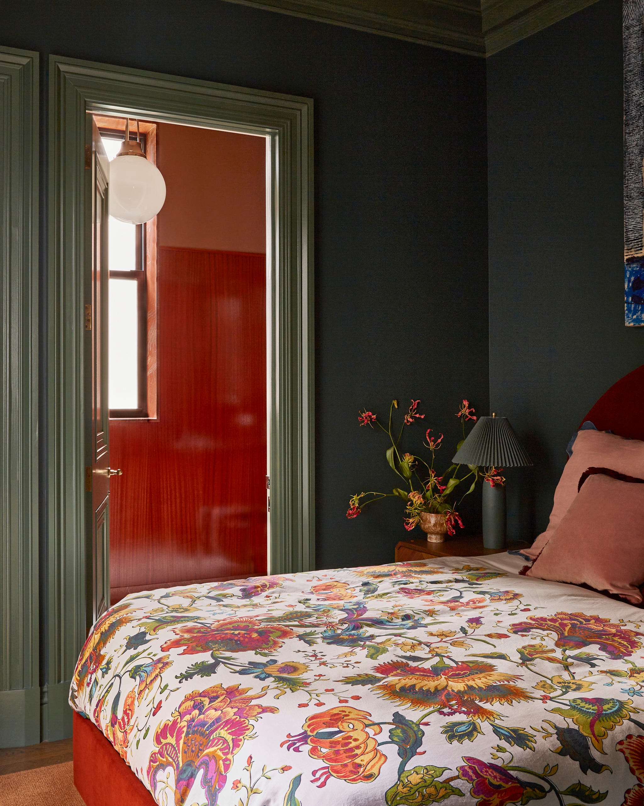 bedroom with colorful floral bedding and walls painted green