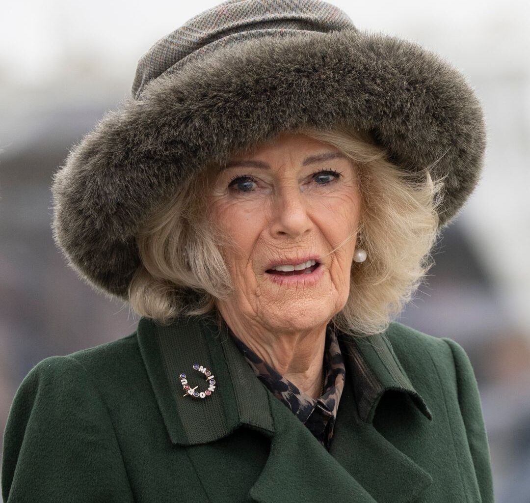 Queen Camilla wearing a green coat and fur hat