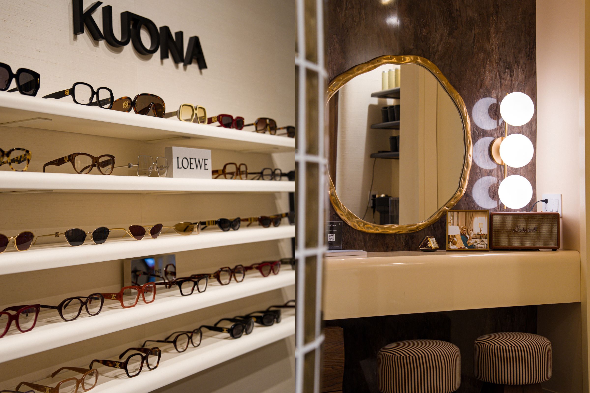 A split-view image showing a luxury eyewear display and a vanity area. On the left, several rows of designer sunglasses and optical frames (including brands like Loewe) are neatly arranged on minimalist white shelves under the "KUONA" brand logo. On the right, a stylish vanity features an organic-shaped gold-rimmed mirror, a marble-patterned backsplash, and a modern light fixture with three glowing orbs. Two striped stools sit tucked under the vanity counter next to a Marshall speaker.
