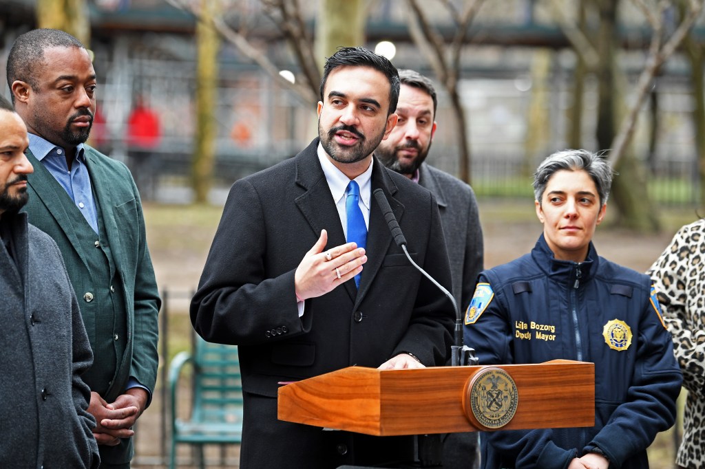 NYC Mayor Zohran Mamdani speaking at a podium with Deputy Mayor Lila Bozorg beside him.