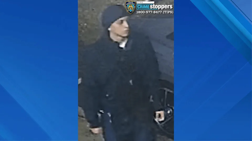 Police are searching for a man accused of stabbing a woman multiple times at an intersection in Queens on Monday morning