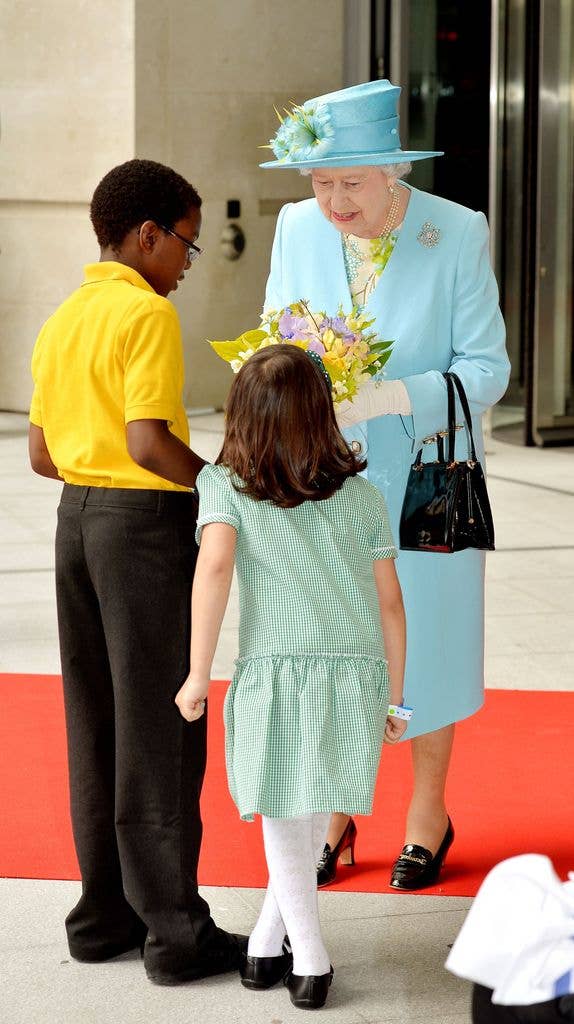 Queen Elizabeth II is handed some flowers after officially opening the BBC's new broadcasting house