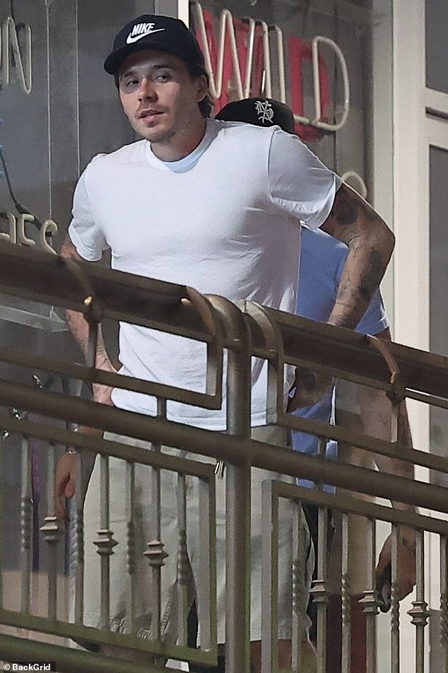 Brooklyn kept it laid-back for dinner in a simple white T-shirt paired with a dark baseball cap, light brown shorts, and white socks