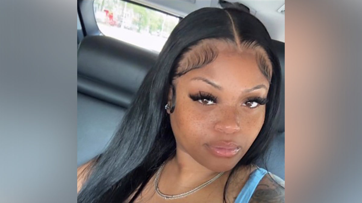 Naya Brown poses for a selfie inside a car, looking at the camera with a neutral expression.