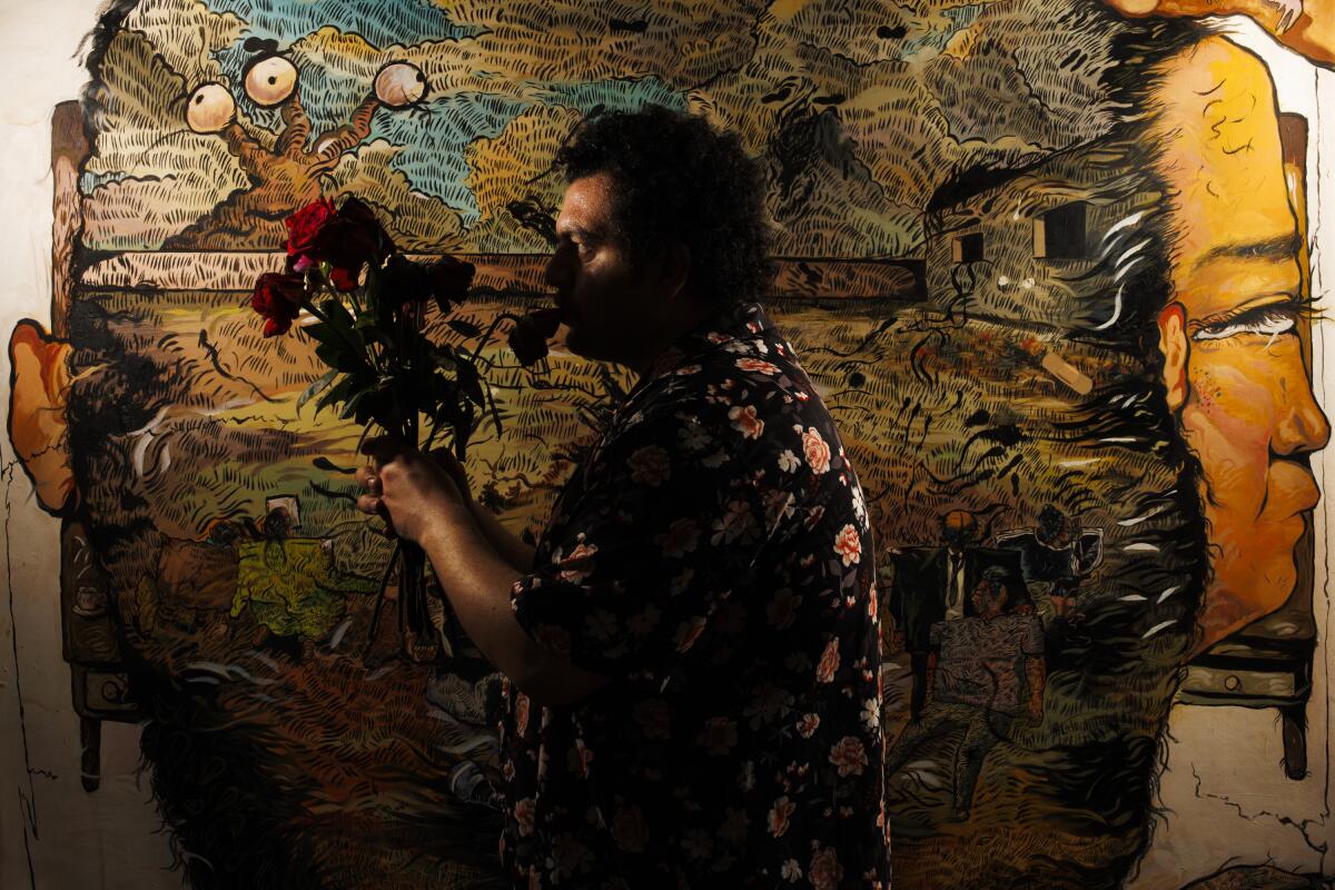 A man stands in shadow in front of a canvas.