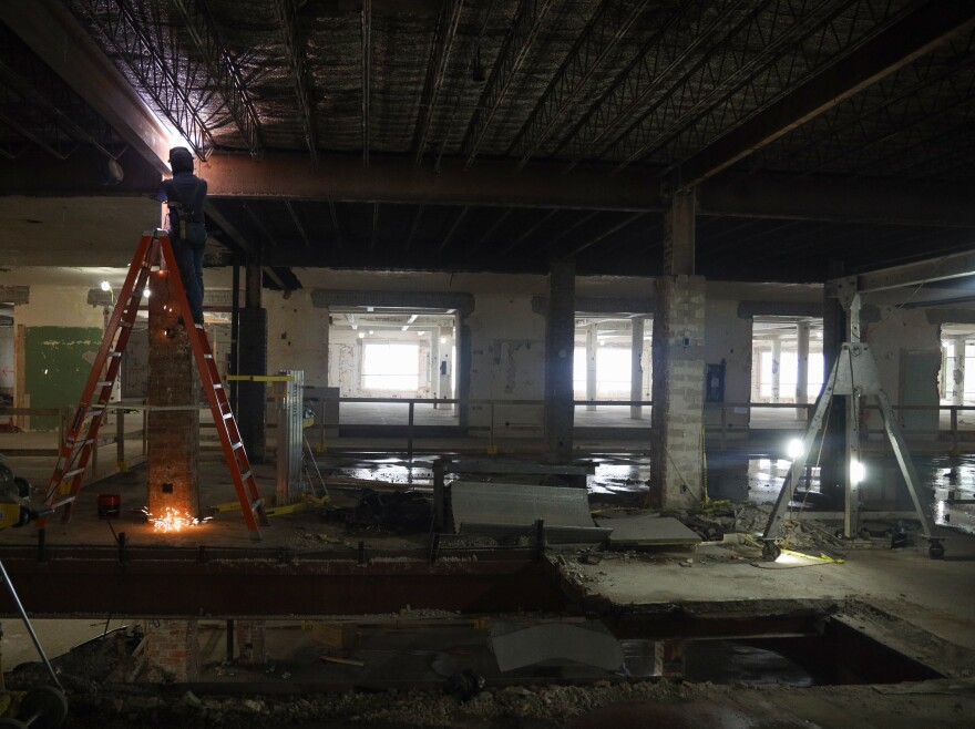 A steel beam is welded into place inside what was once office space being converted into the Gateway Apartments in Rochester, N.Y., before a section of floor is removed to create an atrium that will allow light to reach all seven floors. The development will include studio, one- and two-bedroom units ranging from about 875 to 1,800 square feet—roughly the size of a modest three-bedroom house. The building sits midblock between St. Paul Street and North Clinton Avenue.