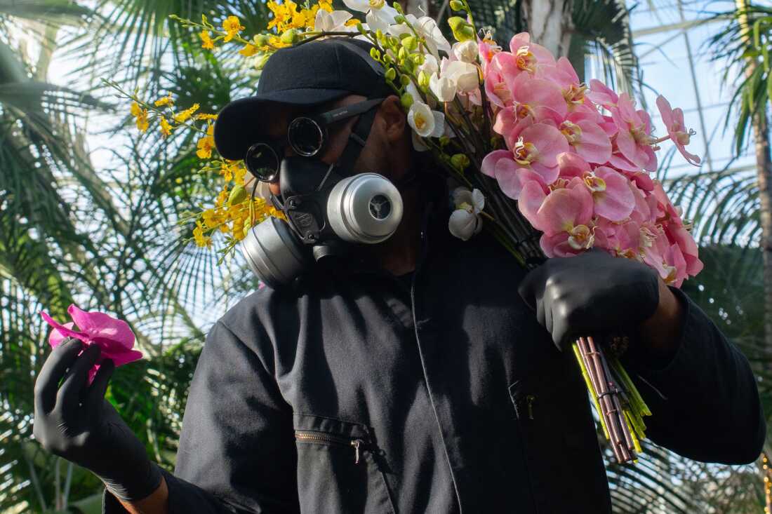 Mr. Flower Fantastic wears a gas mask and gloves because he's allergic to flowers.