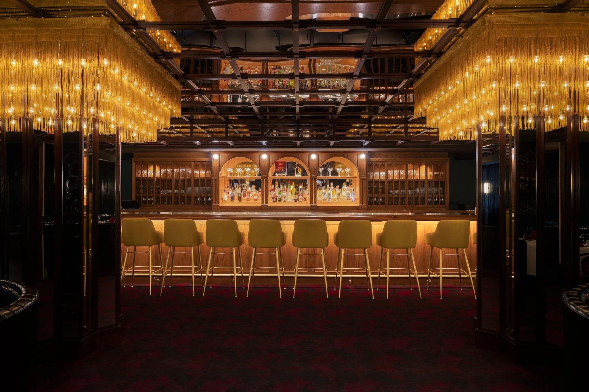 A bar with a mirrored ceiling and fringe