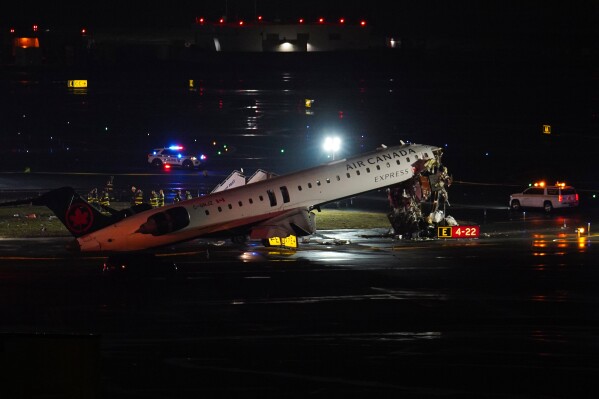 An Air Canada Jet sits on the runway at LaGuardia Airport, Monday, March 23, 2026, after colliding with a Port Authority aircraft rescue and firefighting vehicle in New York. (AP Photo/Ryan Murphy)