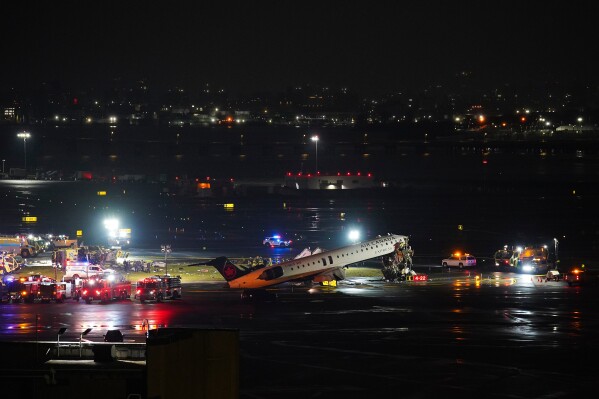 An Air Canada Jet sits on the runway at LaGuardia Airport, Monday, March 23, 2026, after colliding with a Port Authority aircraft rescue and firefighting vehicle in New York. (AP Photo/Ryan Murphy)