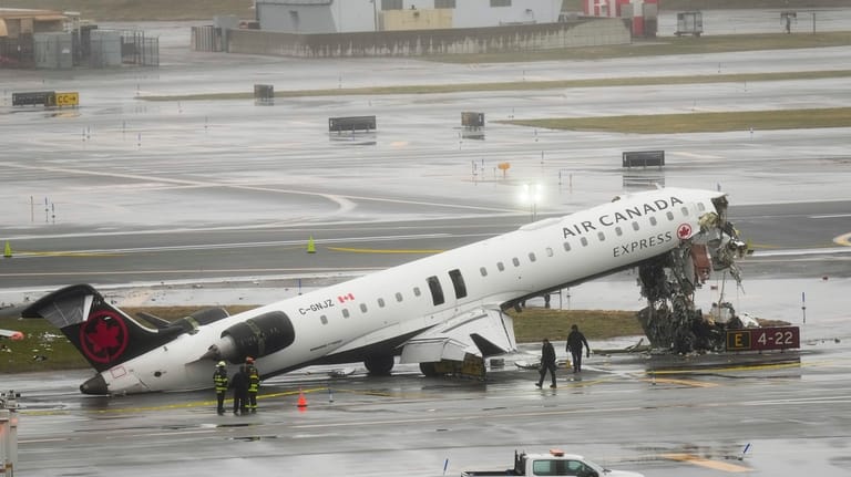 Firefighters and investigators examine the site, Monday, March 23, 2026,...