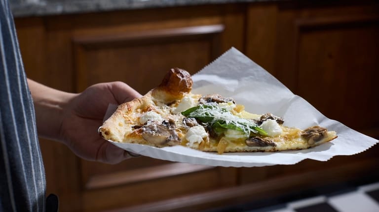 A slice of funghi pizza at Dough & Co. in...