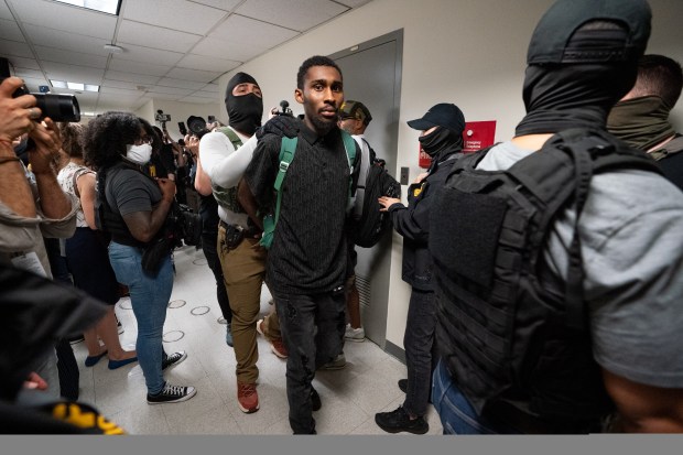 Federal law enforcement officers take an immigrants into custody inside the Jacob K. Javits Building in Manhattan on July 3, 2025.