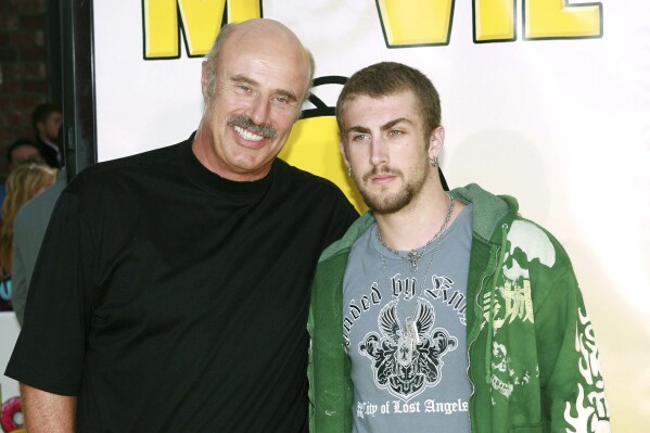 Dr. Phil McGraw, left, and his son, Jordan McGraw, arrive at the premiere of 'The Simpsons Movie' in Los Angeles, July 24, 2007. (AP Photo/Matt Sayles, File)