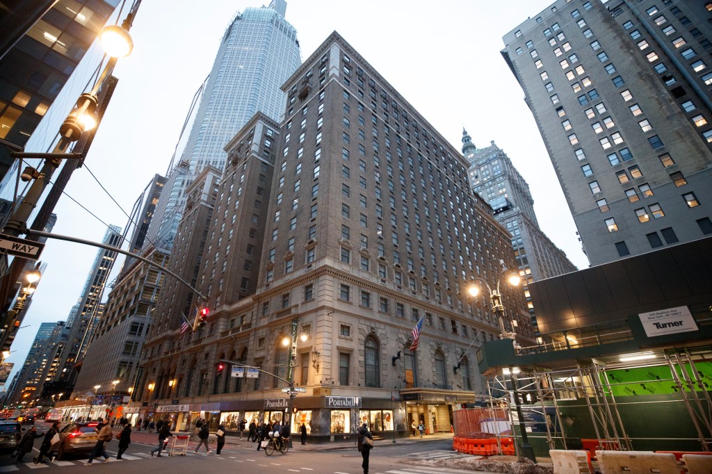 The Roosevelt Hotel in NYC, seen from the street, with pedestrians and cars in the foreground.