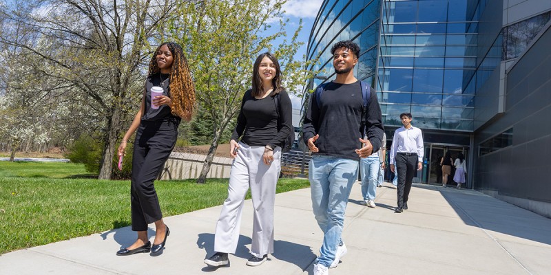 Binghamton University School of Management students outside the Academic A building on campus.