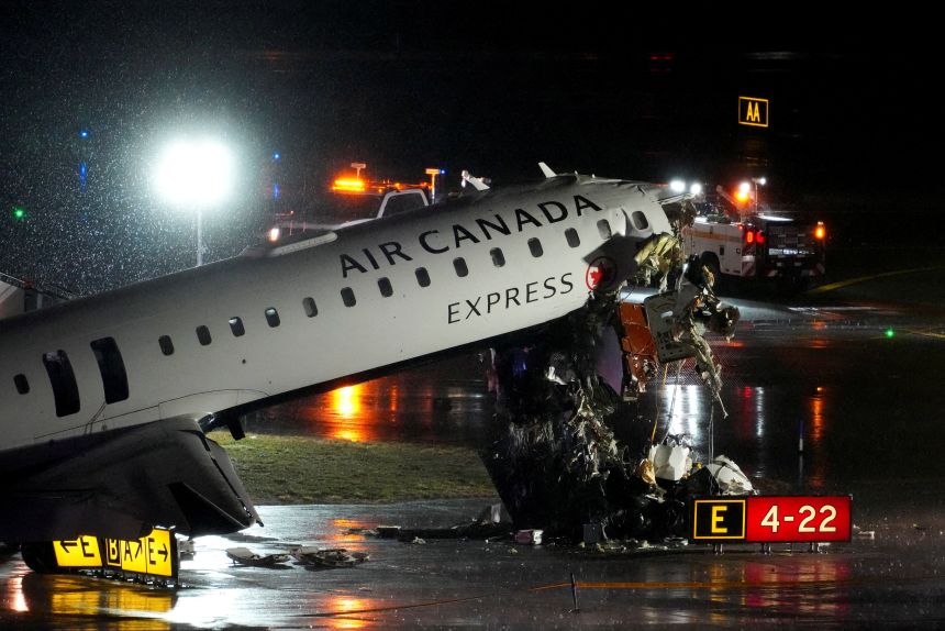 Debris hangs from a damaged Air Canada jet that collided with a fire truck while landing Monday night at New York's LaGuardia Airport.