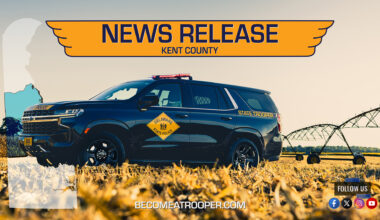 Graphic titled “News Release Kent County” featuring a Delaware State Police Chevrolet Tahoe parked in a crop field with farming equipment in the background. A silhouette map of Delaware appears on the left with Kent County highlighted in blue, the text “BecomeATrooper.com” on the bottom center, and social media icons are shown at the bottom right corner.